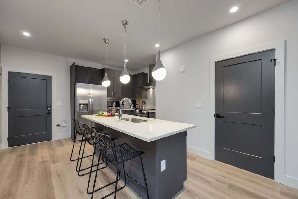 Unit 1: Fully equipped kitchen stocked with your basic cooking essentials. Includes stainless steel appliances, kitchen island, coffee machine, and toaster.