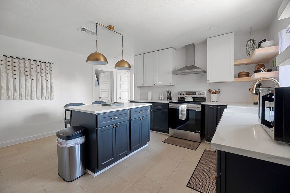 Bright designer kitchen with island, quartz counters, and stylish finishes
