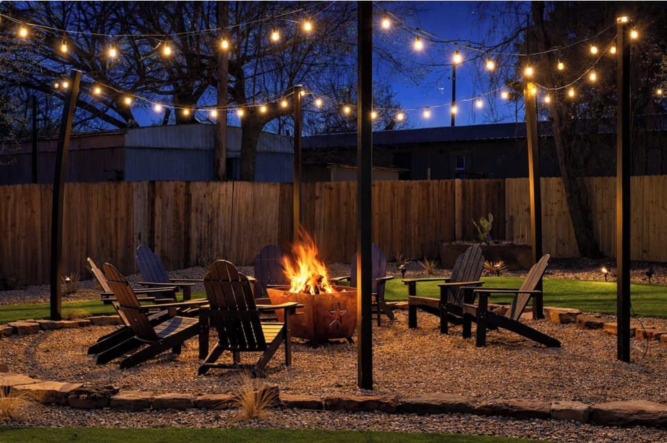 Cozy backyard fire pit under café lights—perfect for evening gatherings