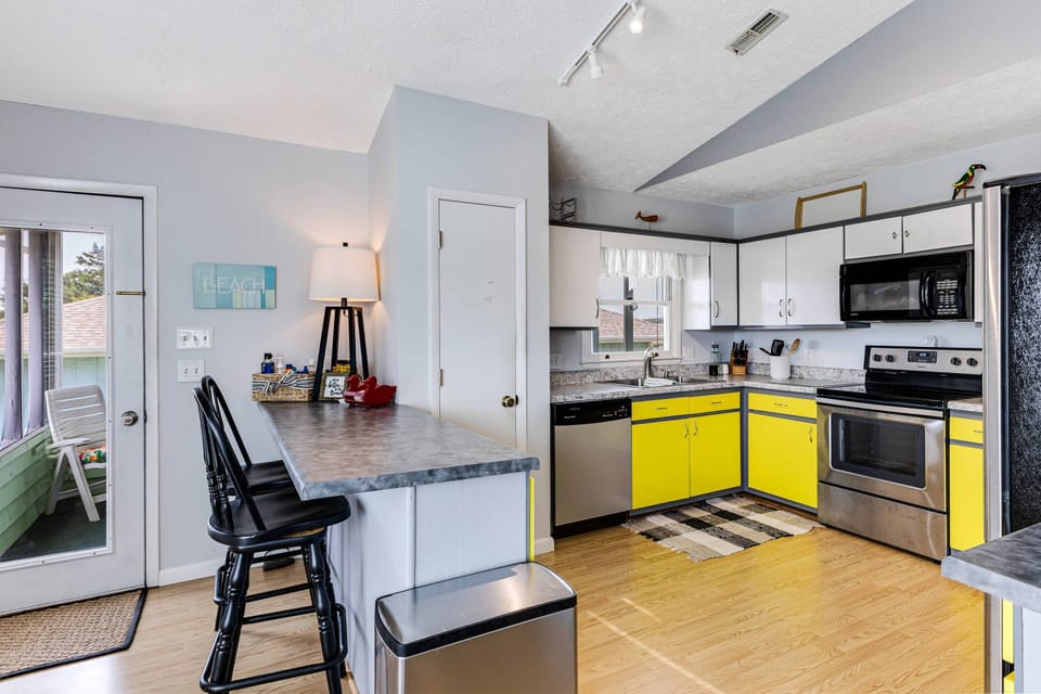 Bright and inviting kitchen with bar and 2 stools.