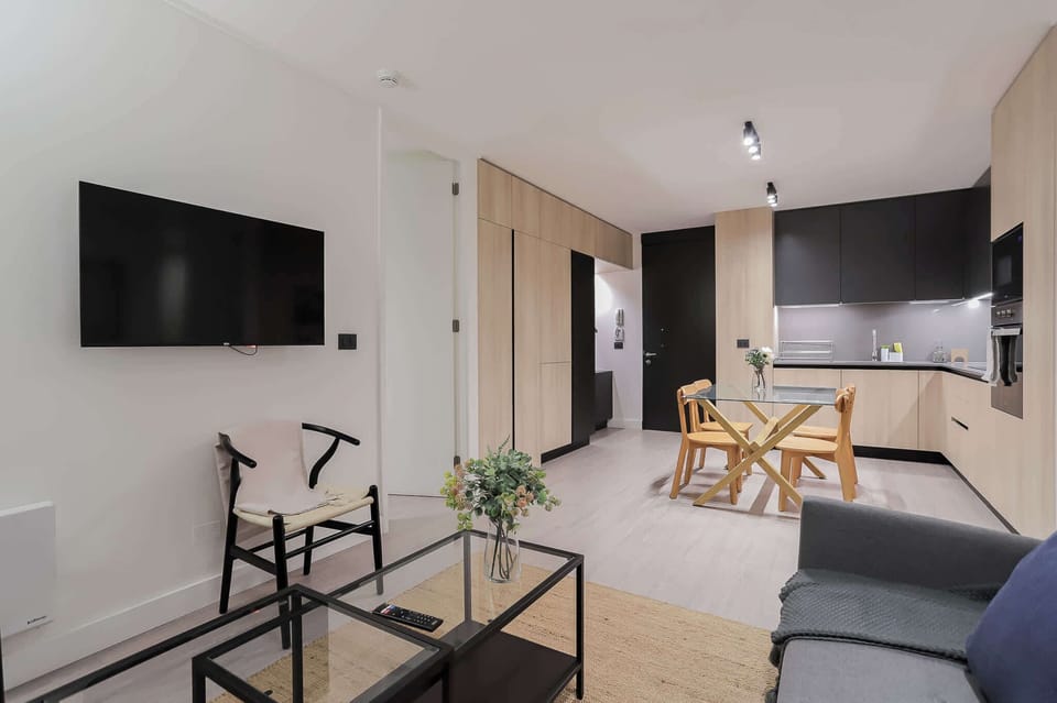 Experience modern comfort in this stylish open-plan living space with sleek kitchen and cozy dining area, perfect for relaxing or entertaining.