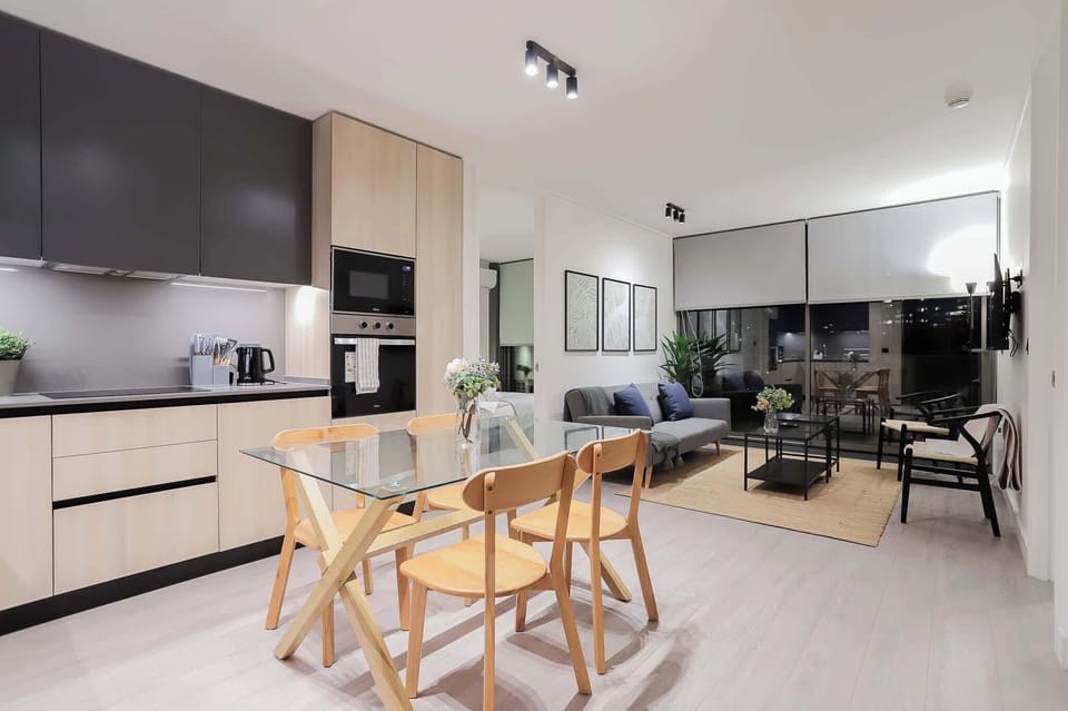 Experience modern living in this stylish open-plan space, perfect for dining and relaxation with city views through expansive windows.