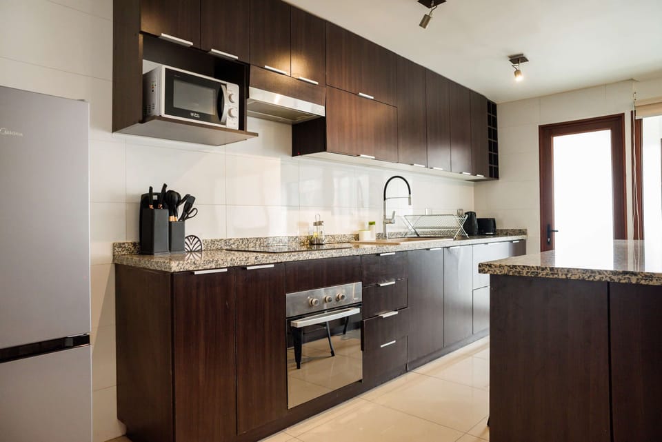 Experience culinary delight in this sleek kitchen with granite countertops and stainless steel appliances.
