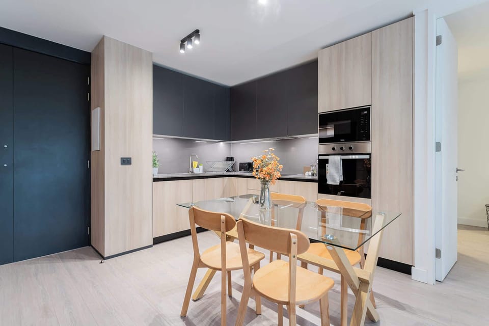 Sleek, modern kitchen with a glass dining table, perfect for enjoying meals together in style.