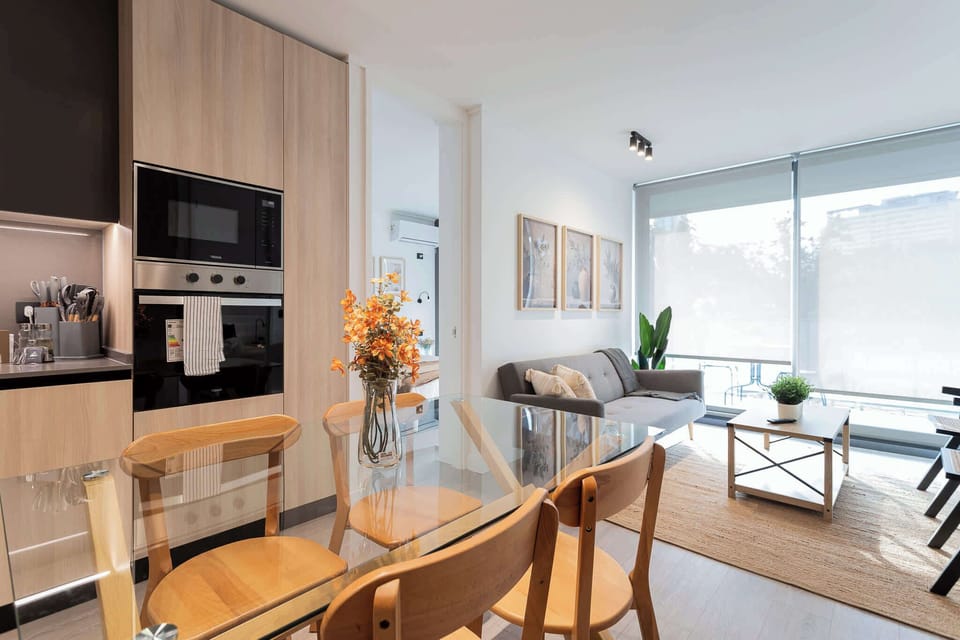 Enjoy a modern, open-plan living space with a sleek kitchen, cozy seating, and abundant natural light, perfect for relaxation and dining.