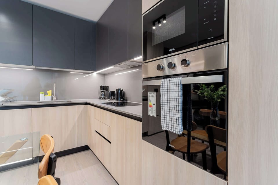 Experience modern elegance in this sleek kitchen, equipped with high-end appliances and a minimalist design perfect for culinary adventures.