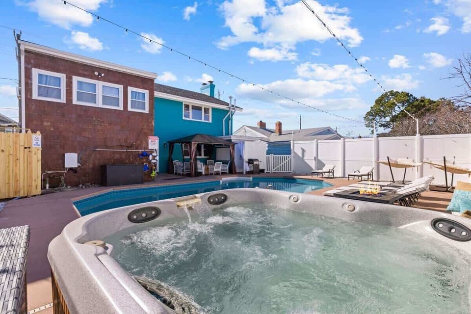 A cozy hot tub sits beside the pool, perfect for unwinding after a long day. The setup exudes comfort and relaxation. 