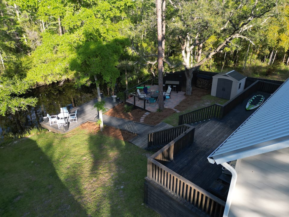 Secluded backyard with dock, fire pit, grill and kayaks.