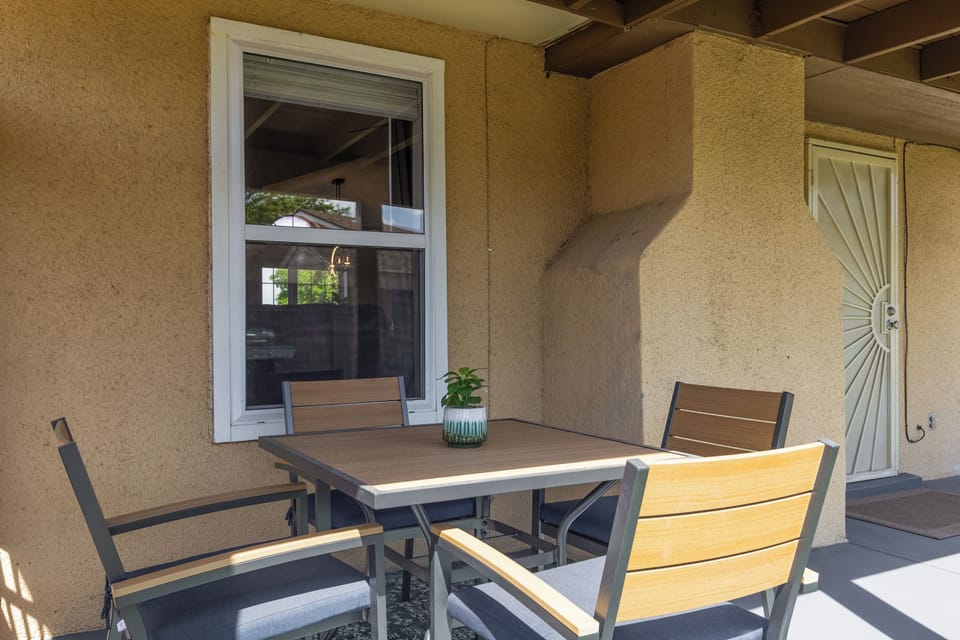 Outdoor padded seating area with peaceful and private backyard.