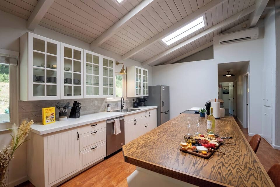 Spacious kitchen with an island irresistible to gather around. Two stools offer additional seating in the dining area. Fully stocked coffee bar with pourover, drip, k-cup, smart kettle, toaster, tea, coffee, sugar, creamer