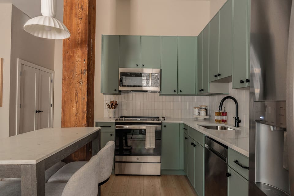Kitchen with stainless steel appliances, and local coffee, tea and sugar.