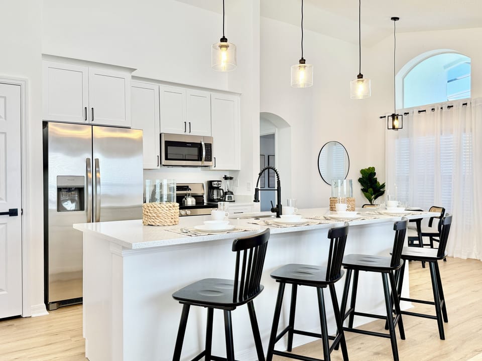 Spacious kitchen with a large countertop and four counter chairs