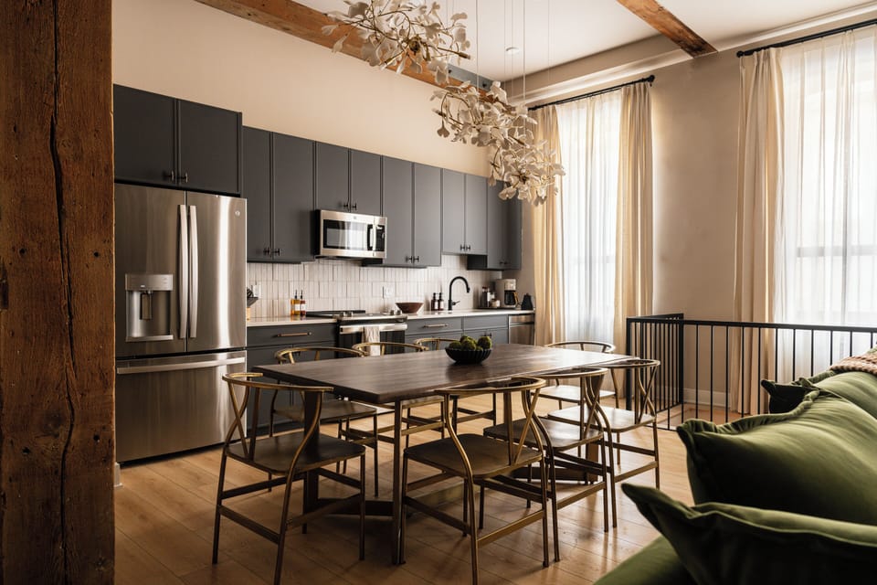 Bright kitchen/dining area with dark cabinets and a sculptural light.