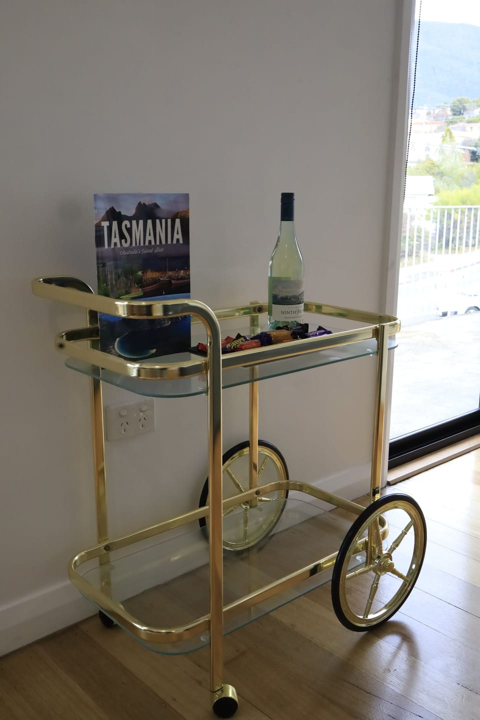 Bar cart with welcome information, complementary chocolates and wine.