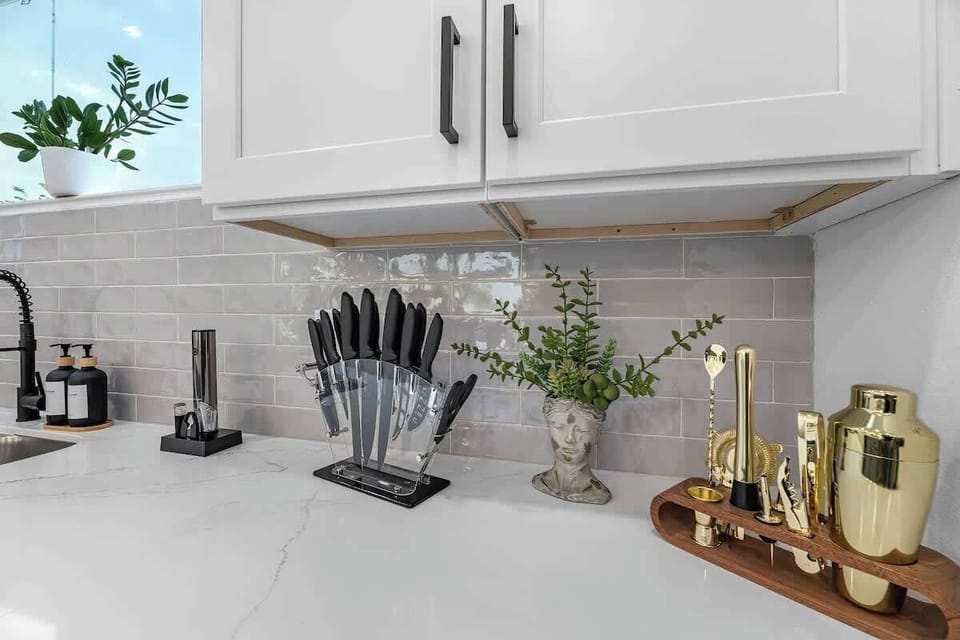 Complete your culinary experience with a well-equipped kitchen featuring a full set of bar tools and a high-quality knife set. Enjoy your adult beverages with the sleek electric wine opener available in the kitchen.