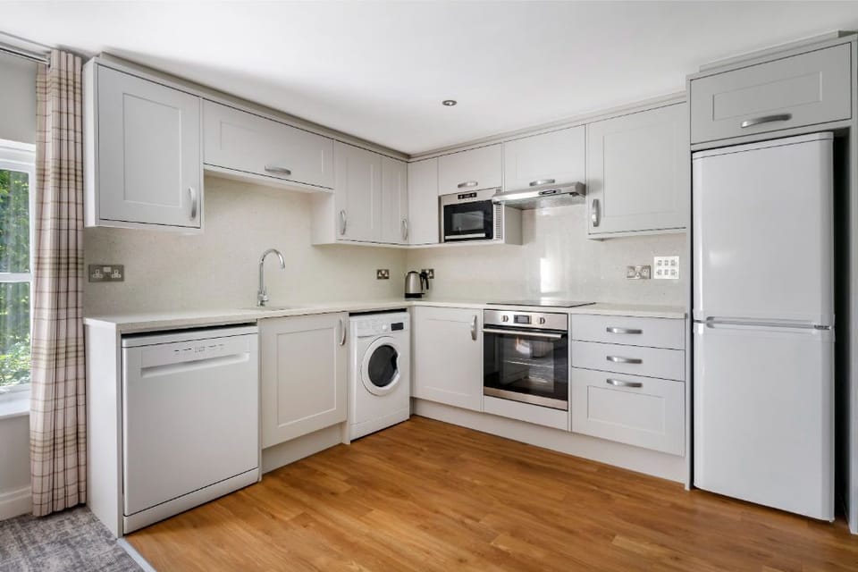 Sleek white kitchen with modern appliances and a welcoming feel.