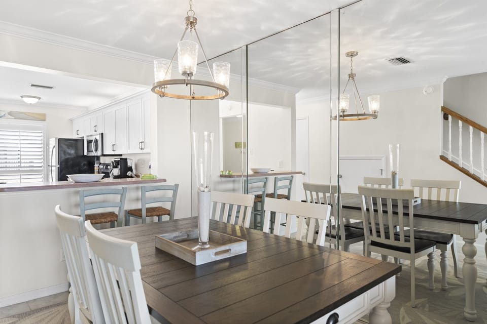 Spacious dining room with seating for the whole family, complemented by mirrors and natural light for an open, airy feel.