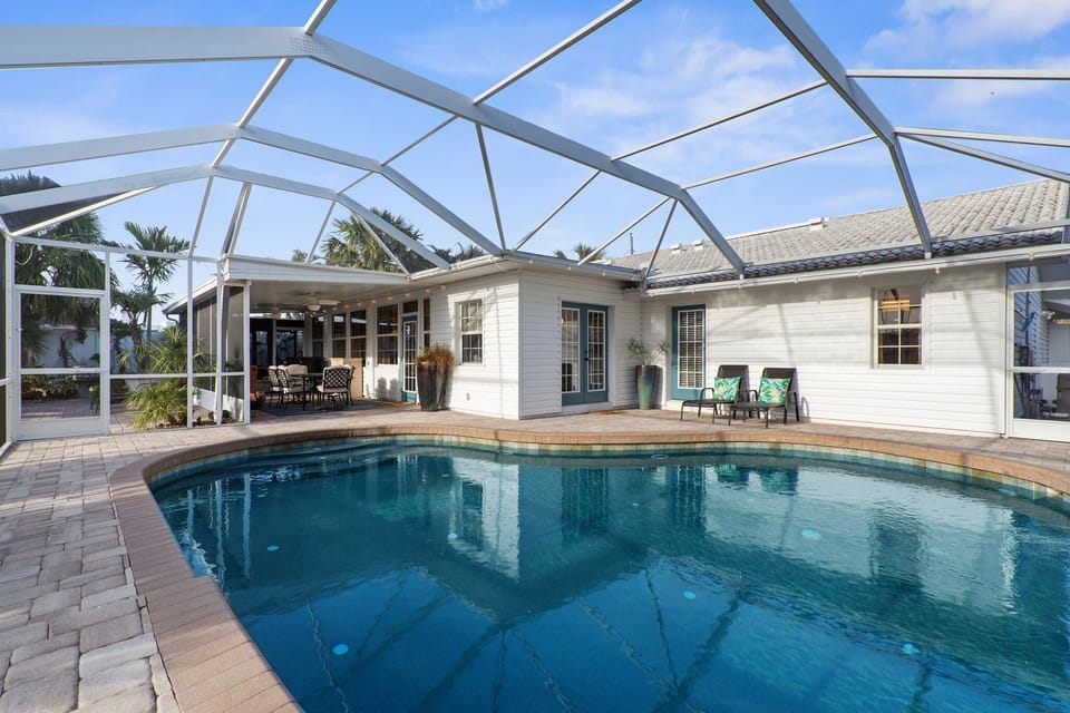 Sink into a lounge chair inside the enclosure and realize the bugs stay outside all week — the screened pool is the kind of setup that makes every other backyard feel ordinary after this.