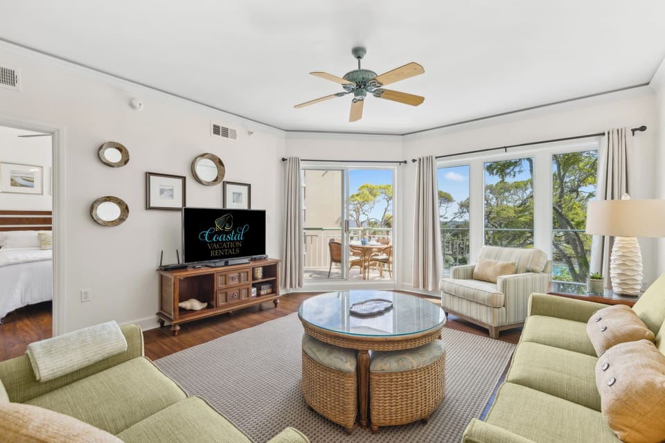 Living room with a flat screen tv, a sleeper sofa, and access to a private balcony with beautiful views.