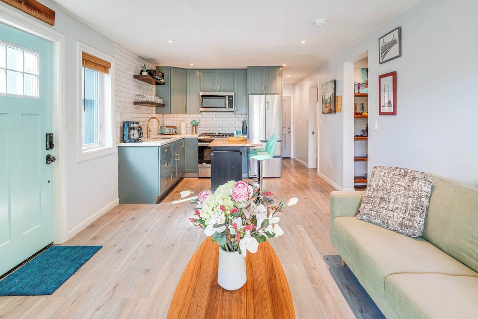 Step into this bright, open-concept living space where soft natural light, warm wood floors, and a stylish kitchen flow seamlessly together for a welcoming and relaxing stay