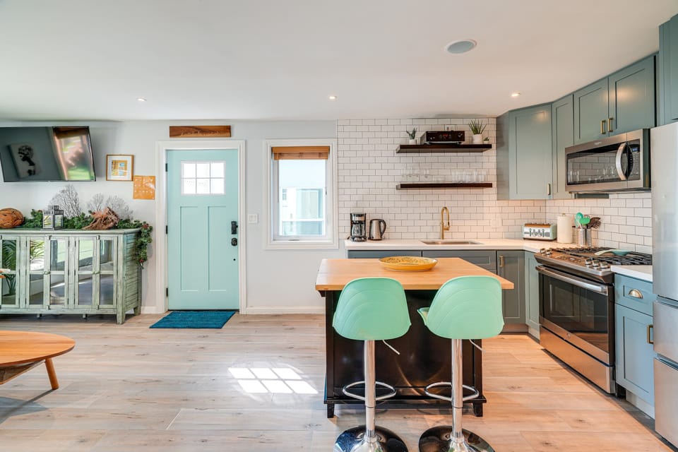 Gather around the charming kitchen island with its mint accents and modern finishes, where bright natural light and clean design create a warm, inviting space to cook, connect, and unwind