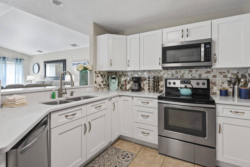 Open-concept kitchen equipped with modern appliances and countertop seating, perfect for cooking and gathering with family and friends.