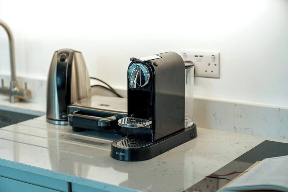 The kitchen features sleek white countertops and cabinets providing a clean and modern aesthetic. The induction cooker offers precise and efficient cooking, allowing you to prepare your favorite dishes with ease. 