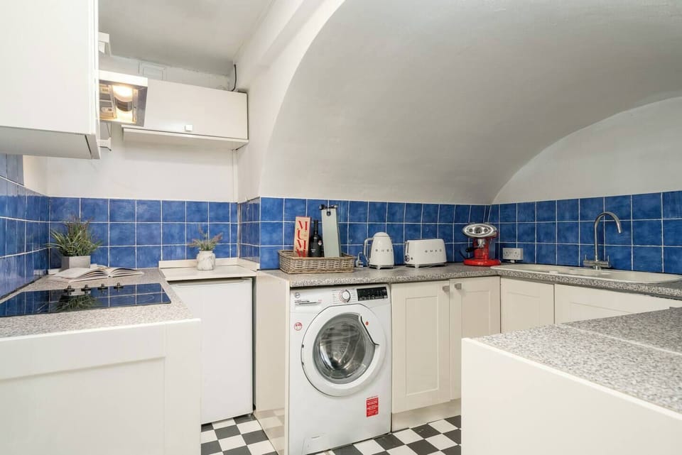 This kitchen is designed for functionality, featuring a washing machine and ample counter space for your culinary needs. 