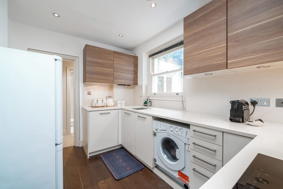 The kitchen features sleek white countertops ad maple overhead cabinets providing a clean and modern aesthetic. The induction cooker offers precise and efficient cooking, allowing you to prepare your favorite dishes with ease. 
