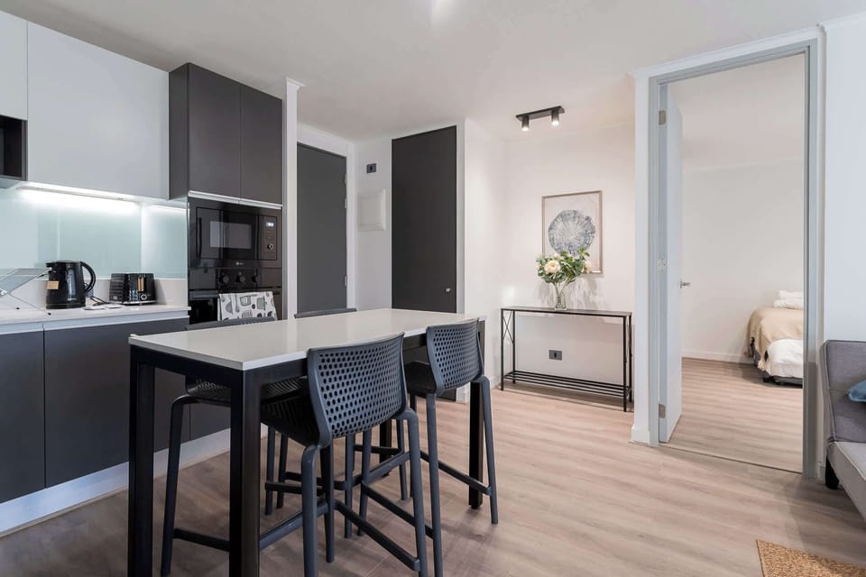 Modern kitchen and dining area with sleek design and ample seating, perfect for cozy meals.