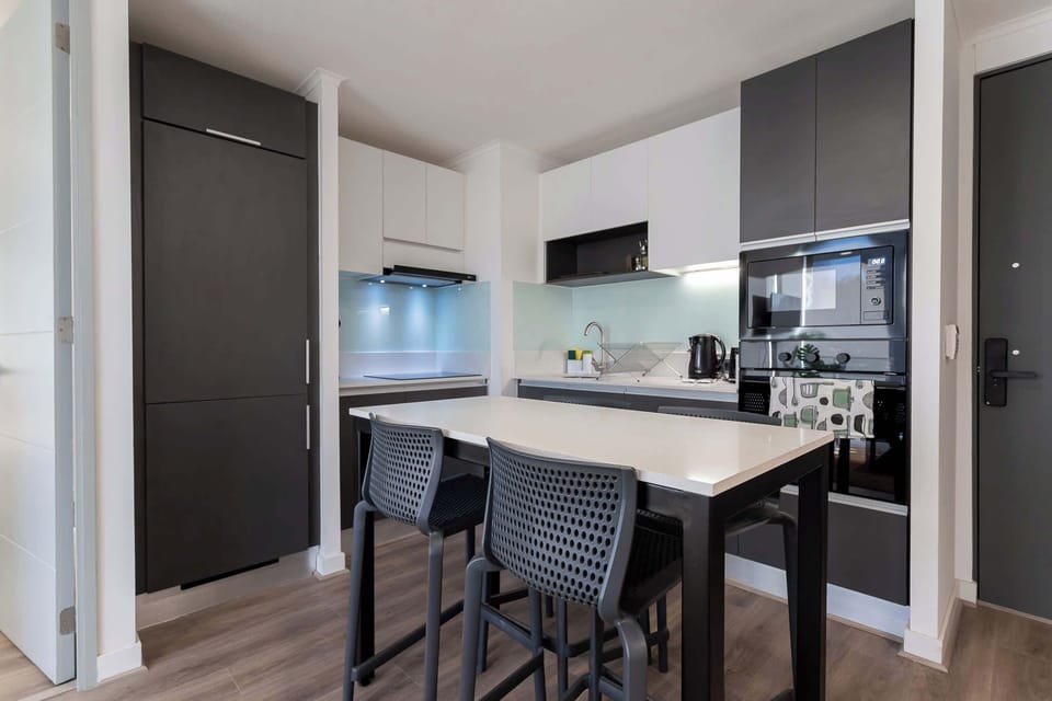 Sleek and modern kitchen with high-end appliances and a cozy dining area, perfect for intimate meals.