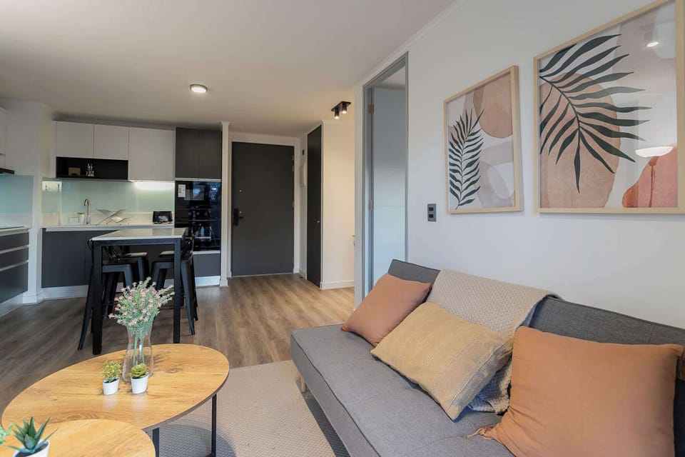 Chic open-plan living room with stylish decor and a modern kitchen, perfect for relaxing and entertaining.