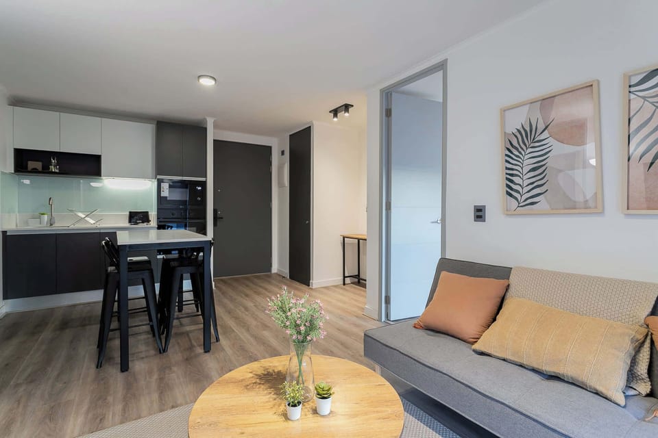 Chic open-plan living area with modern kitchen and cozy seating, perfect for relaxing after a day of exploring.