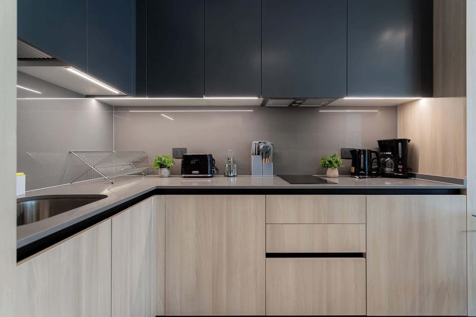 Experience culinary delights in this modern kitchen, featuring sleek cabinetry and top-notch appliances for a stylish cooking experience.
