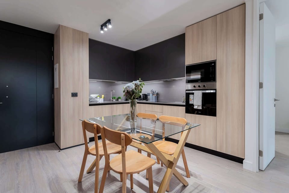Experience modern living in this stylish kitchen, featuring sleek cabinetry and a cozy dining area perfect for meals and gatherings.