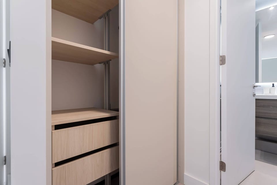 Spacious closet with ample storage next to a modern bathroom—perfect for organizing your stay.