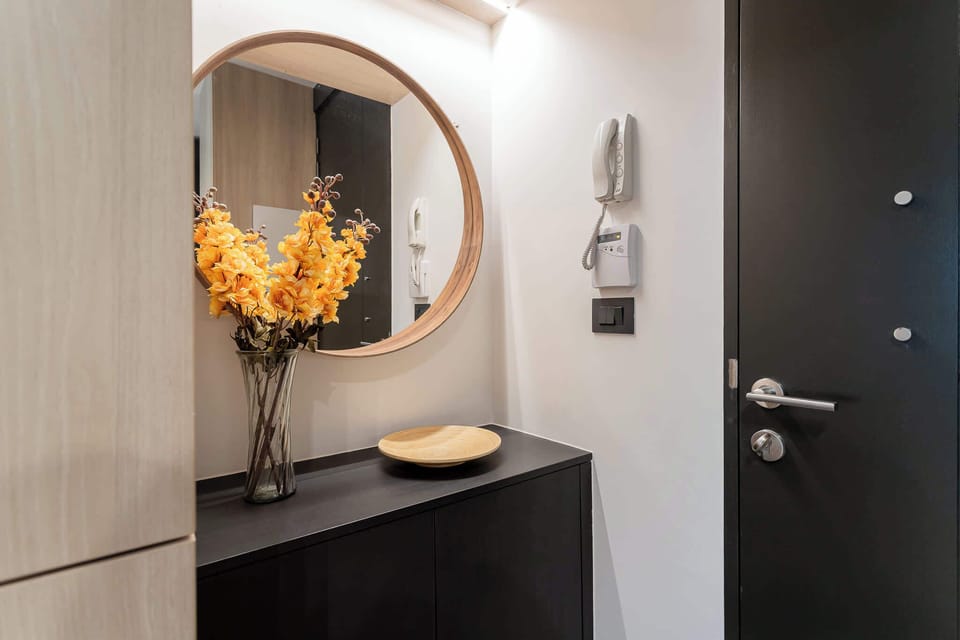 Step into a stylish entryway adorned with vibrant flowers and modern decor, setting the tone for a memorable stay.