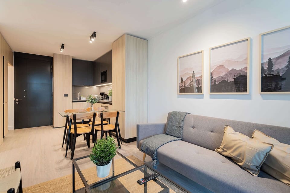 Experience modern comfort in this stylish living space, featuring a cozy sofa, dining area, and chic decor for a perfect getaway.