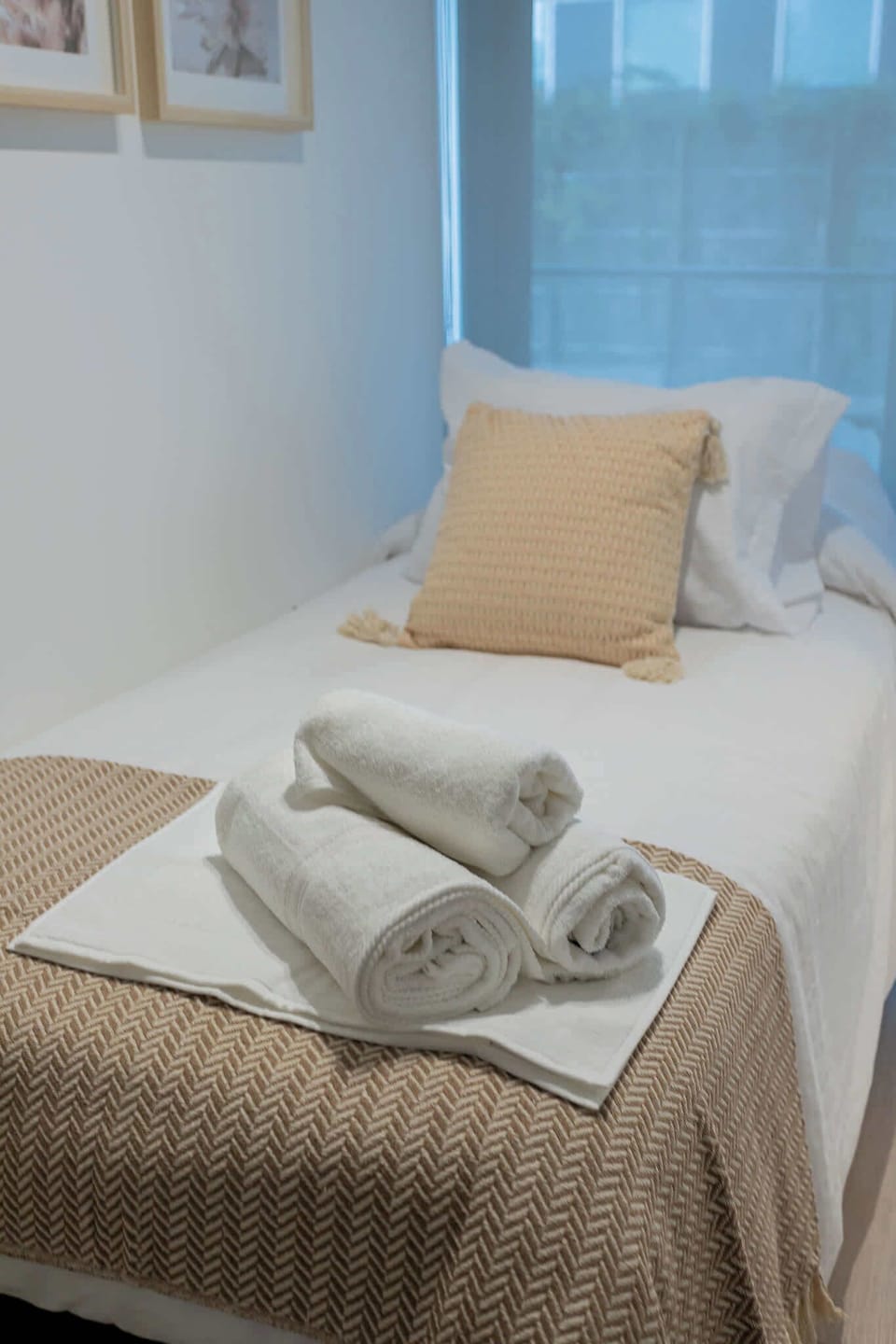 Cozy single bed with fresh linens and towels, perfect for a restful stay.