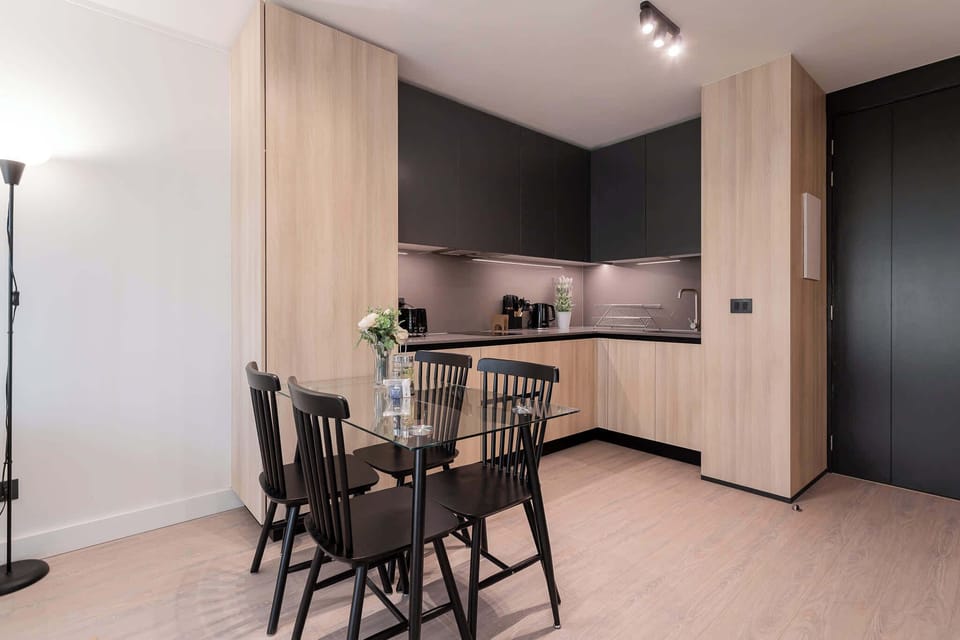 Experience modern living in this stylish kitchen, featuring sleek cabinetry and a cozy dining area perfect for meals and gatherings.