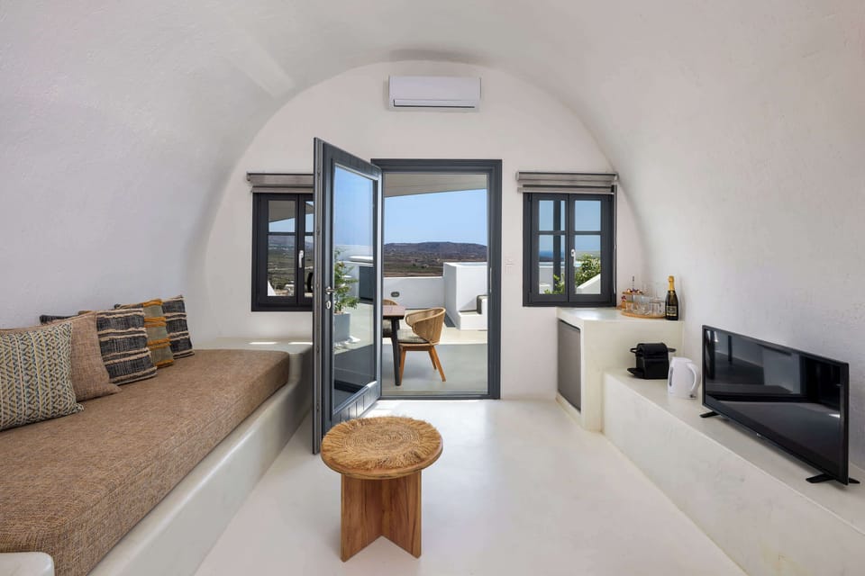 Living Room Area with Cycladic Minimalism
Features built-in furniture, soft tones, a center table, and a window offering natural light.