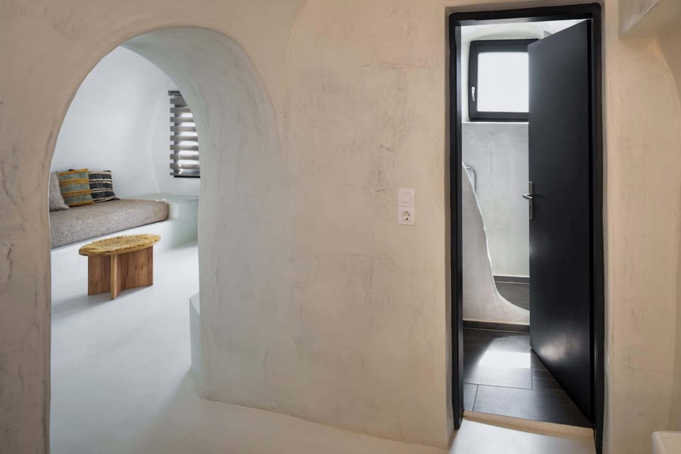 Cycladic Hallway Connecting Bedroom and Bathroom
Arched hallway with decorative alcove, leading into private rooms.