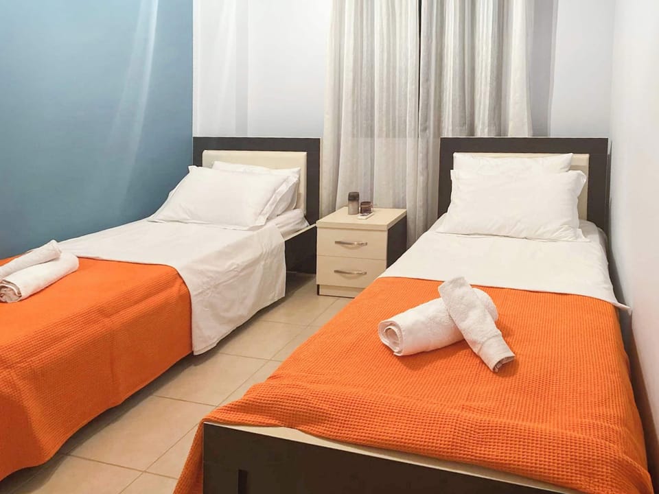 Stylish twin room with cheerful colors and thoughtful design, offering both comfort and privacy