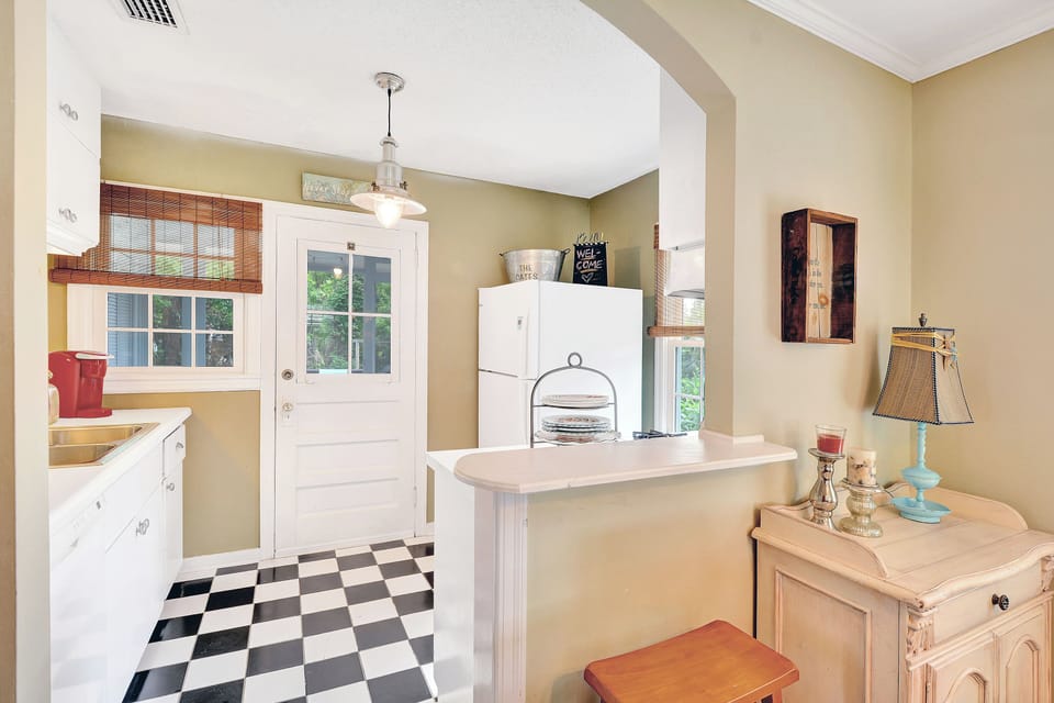 Kitchen Back Door and Counter Area - Kitchen angle with back door, counter space, sink, refrigerator, and open passage toward the dining room.