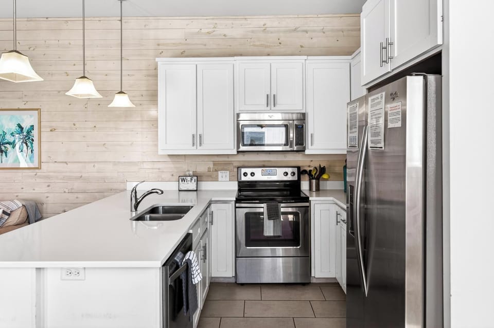Modern coastal kitchen fully stocked for cooking, gathering, and vacation dining!