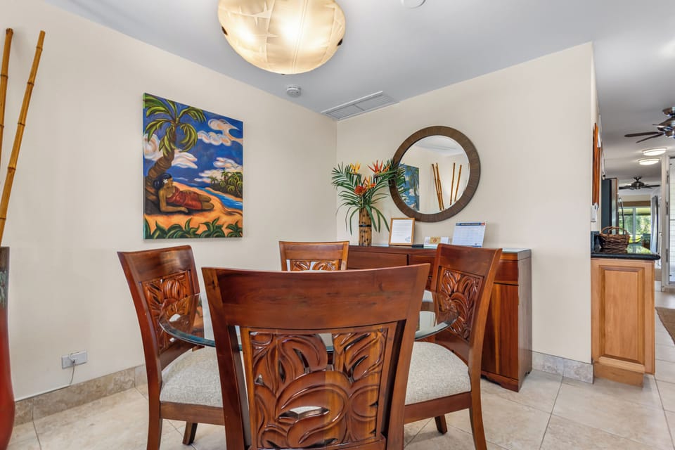 Gather around the beautifully carved tropical-inspired dining table, where your meals become memorable moments beneath the warm, sculptural lighting. Tropical art and thoughtful touches create an inviting space for conversation.