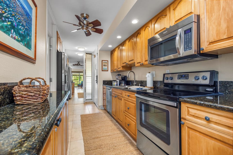 Your fully equipped galley kitchen features modern stainless steel appliances, granite countertops, and warm wood cabinetry—everything you need to create memorable meals during your stay.