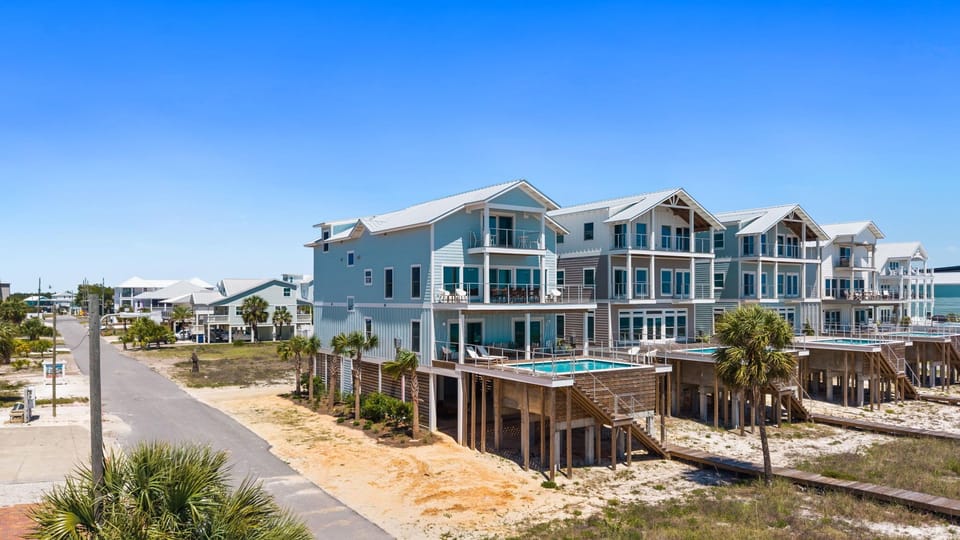 Three-story beachfront property with coastal charm, featuring private pool, covered parking, and direct beach access in a serene neighborhood.