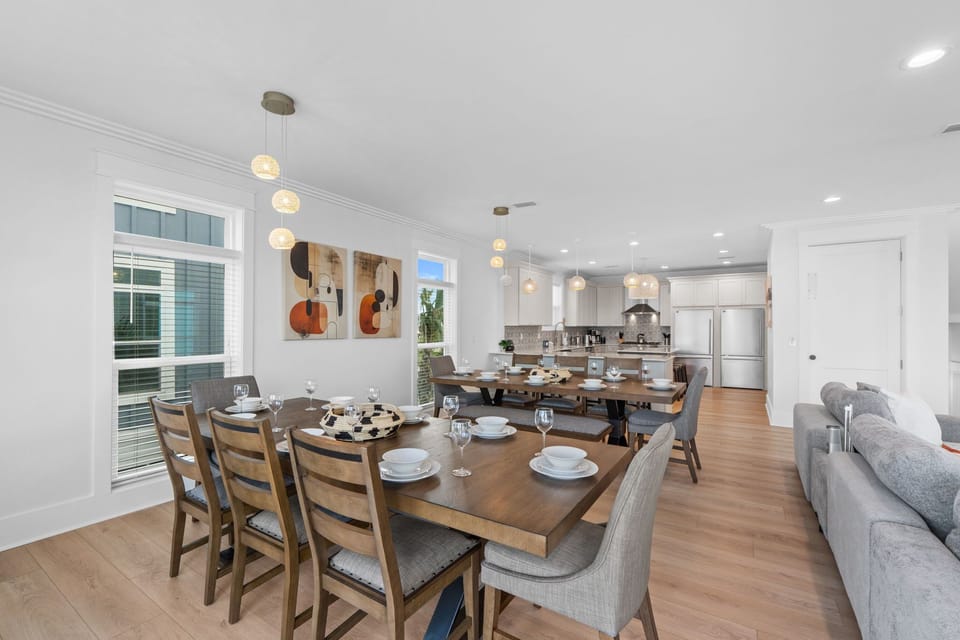 Gather around a spacious table perfect for shared meals, where soft pendant lighting creates intimate ambiance beside your modern, fully-equipped kitchen—your welcoming home away from home.
