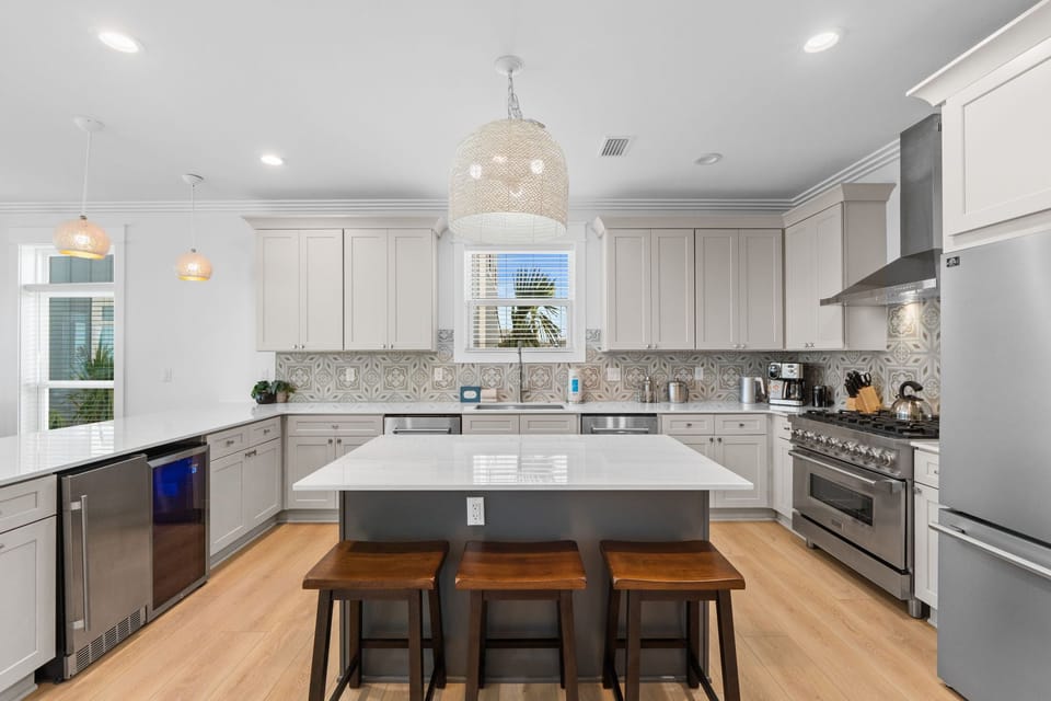 Your gourmet kitchen awaits—gleaming countertops, professional-grade appliances, and an inviting island where you can gather for morning coffee or prepare memorable meals together during your stay.